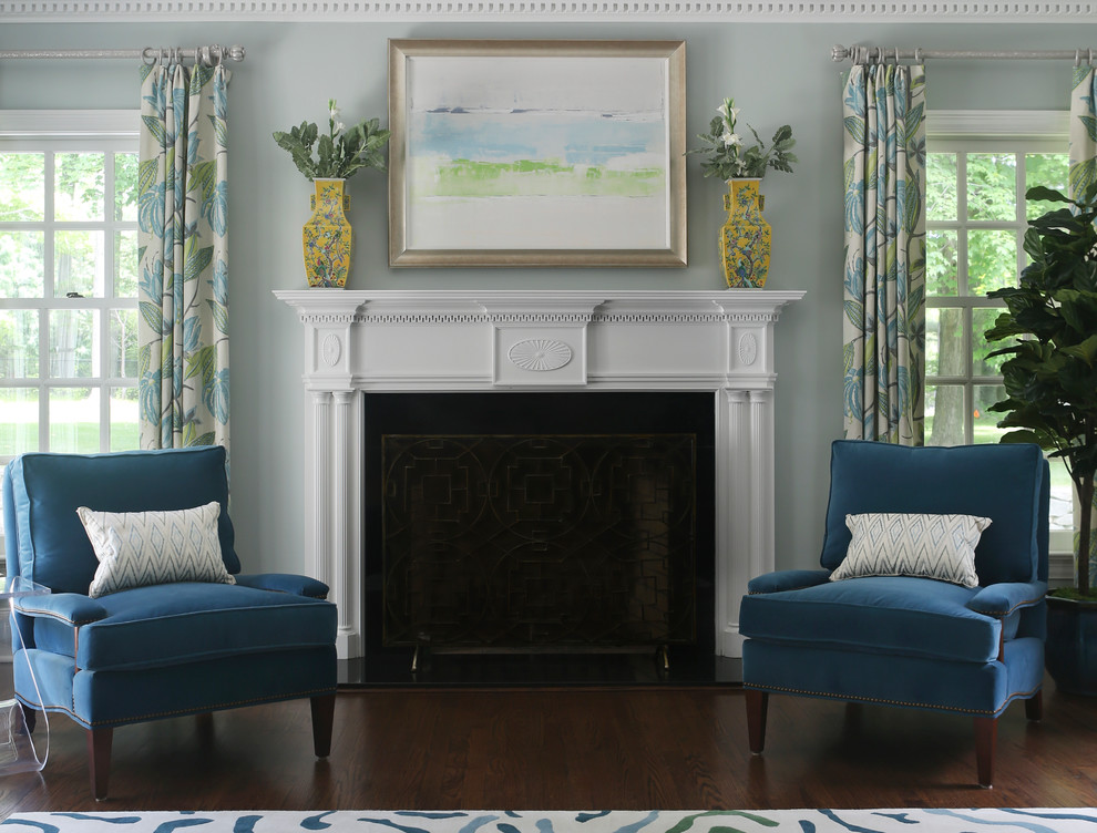Cette image montre un grand salon traditionnel ouvert avec un mur bleu, un sol en bois brun, une cheminée standard et un manteau de cheminée en bois.