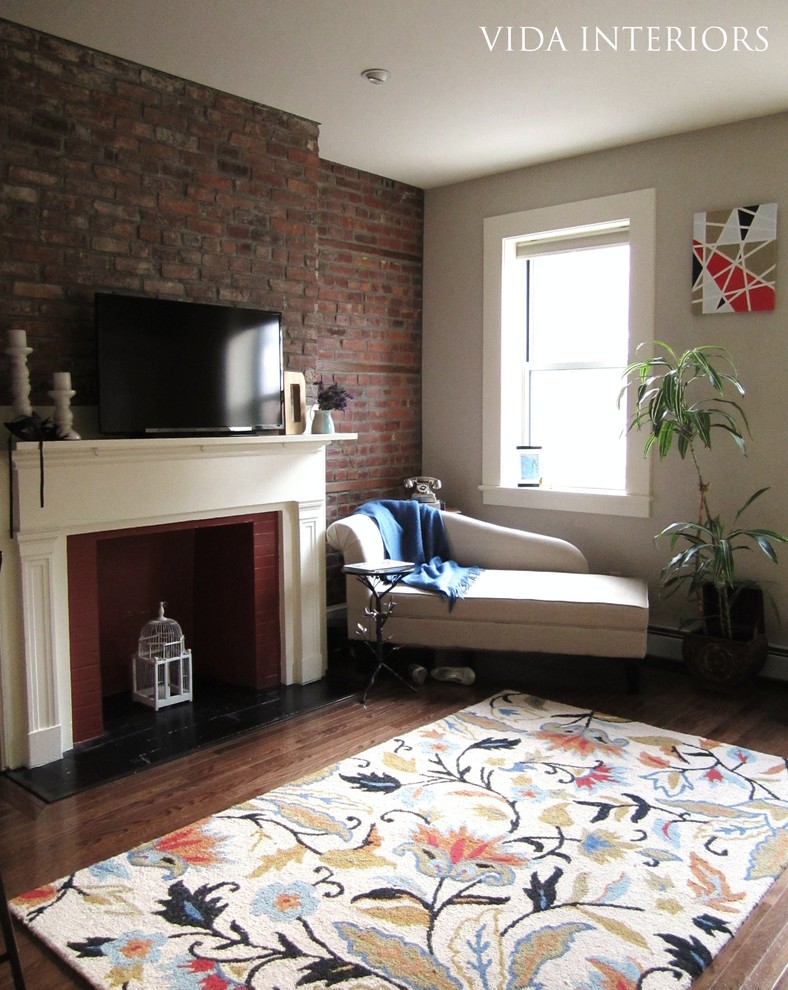 This is an example of an eclectic living room in New York with a brick fireplace surround.