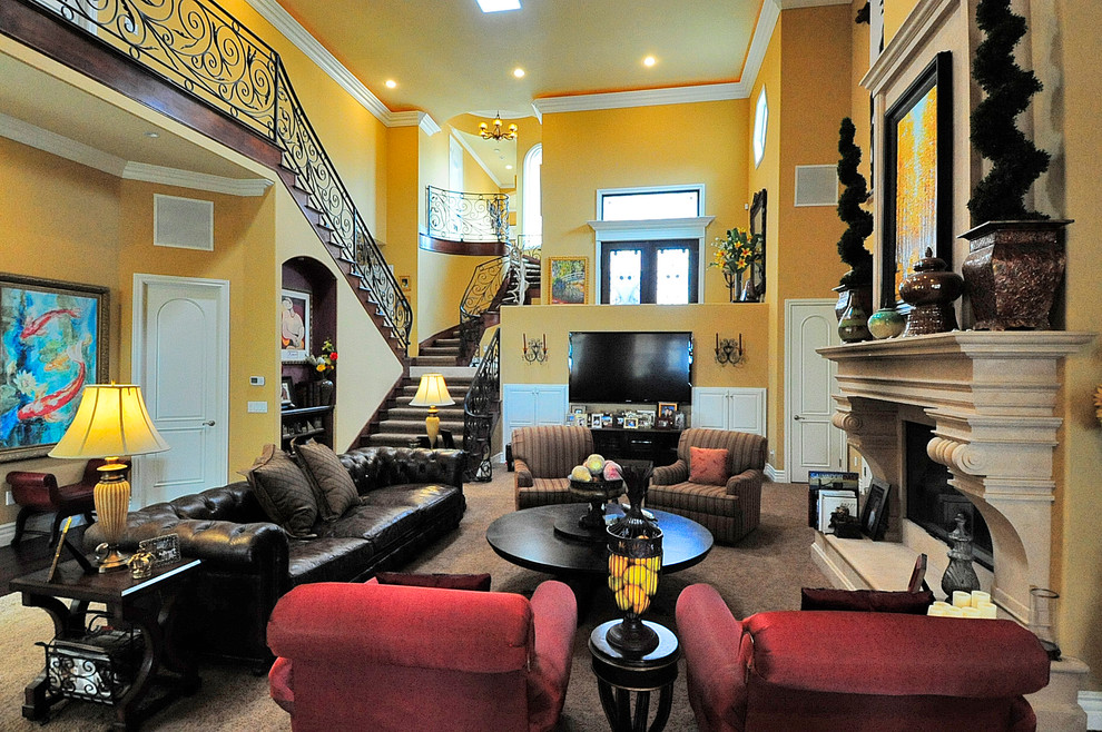 На фото: большая парадная, открытая гостиная комната в средиземноморском стиле с фасадом камина из бетона, желтыми стенами, ковровым покрытием, стандартным камином и коричневым полом