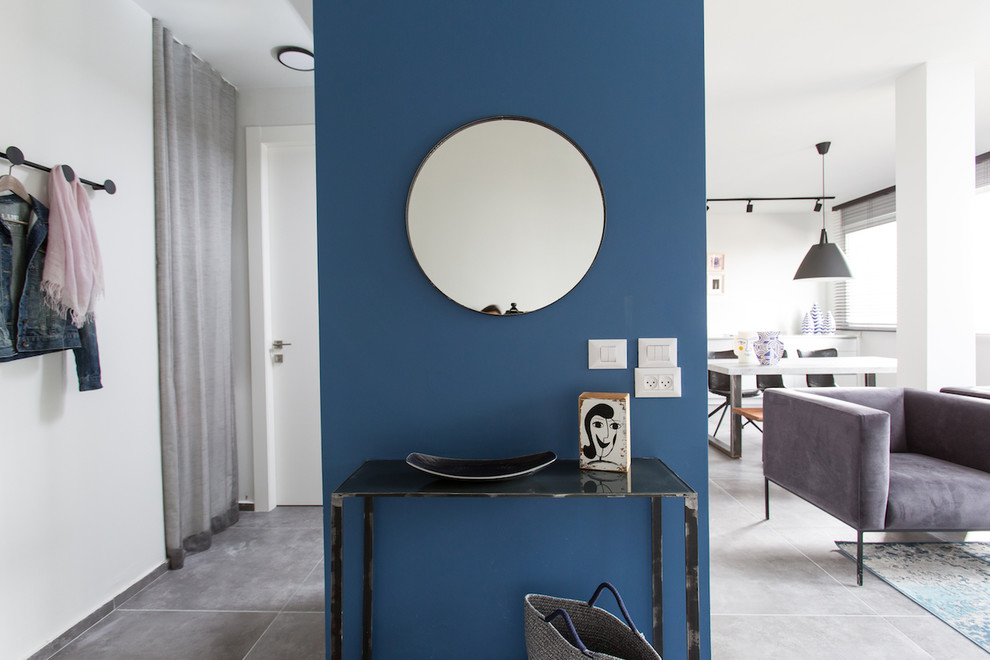 Modern inredning av ett mellanstort loftrum, med vita väggar, klinkergolv i keramik, en väggmonterad TV och grått golv