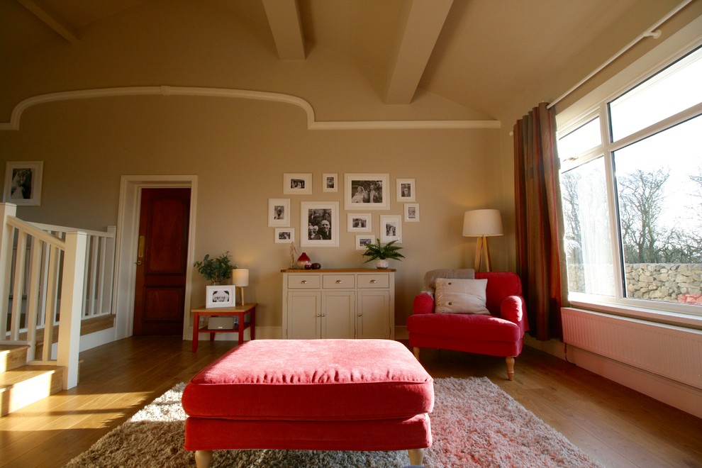 Modelo de salón abierto campestre grande sin televisor con paredes marrones, suelo laminado, estufa de leña y marco de chimenea de piedra