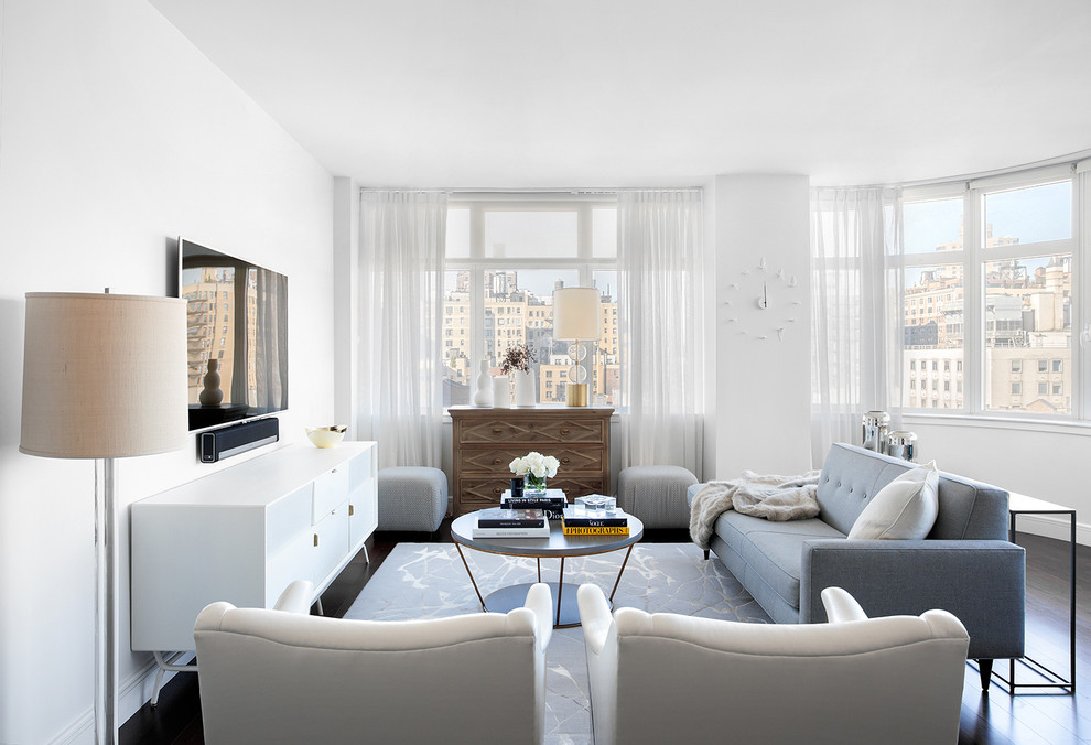 Стильный дизайн: гостиная комната в стиле неоклассика (современная классика) с белыми стенами, темным паркетным полом и телевизором на стене - последний тренд