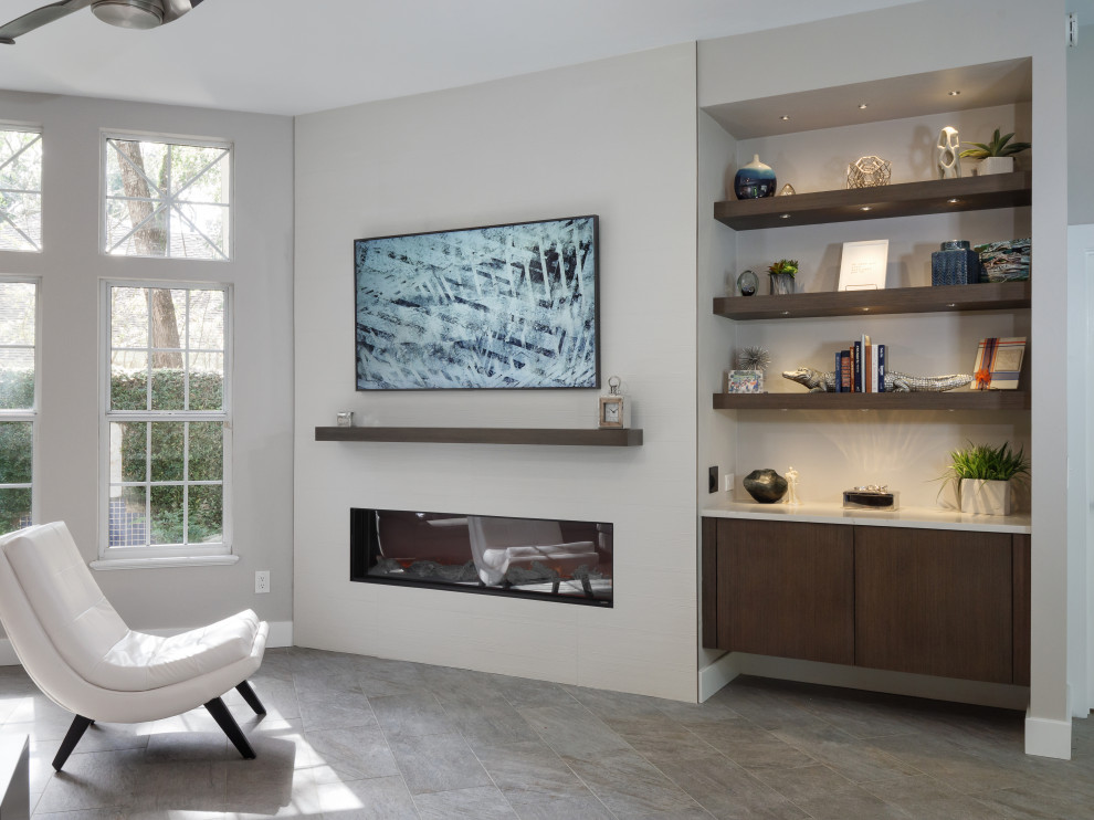 Inspiration for a mid-sized modern open concept porcelain tile and gray floor living room library remodel in Miami with gray walls, a hanging fireplace and a tile fireplace