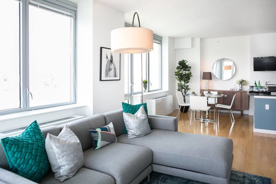 Immagine di un grande soggiorno minimalista chiuso con pareti grigie, parquet chiaro e TV a parete