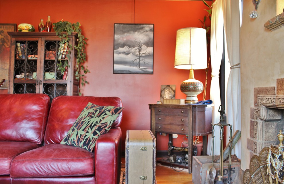 Example of an eclectic enclosed medium tone wood floor living room design in Seattle with red walls, a standard fireplace and a tile fireplace