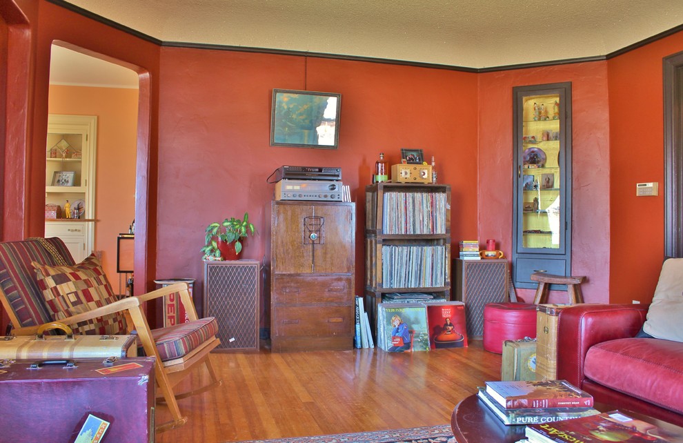 Example of an eclectic enclosed medium tone wood floor living room design in Seattle with red walls, a standard fireplace and a tile fireplace