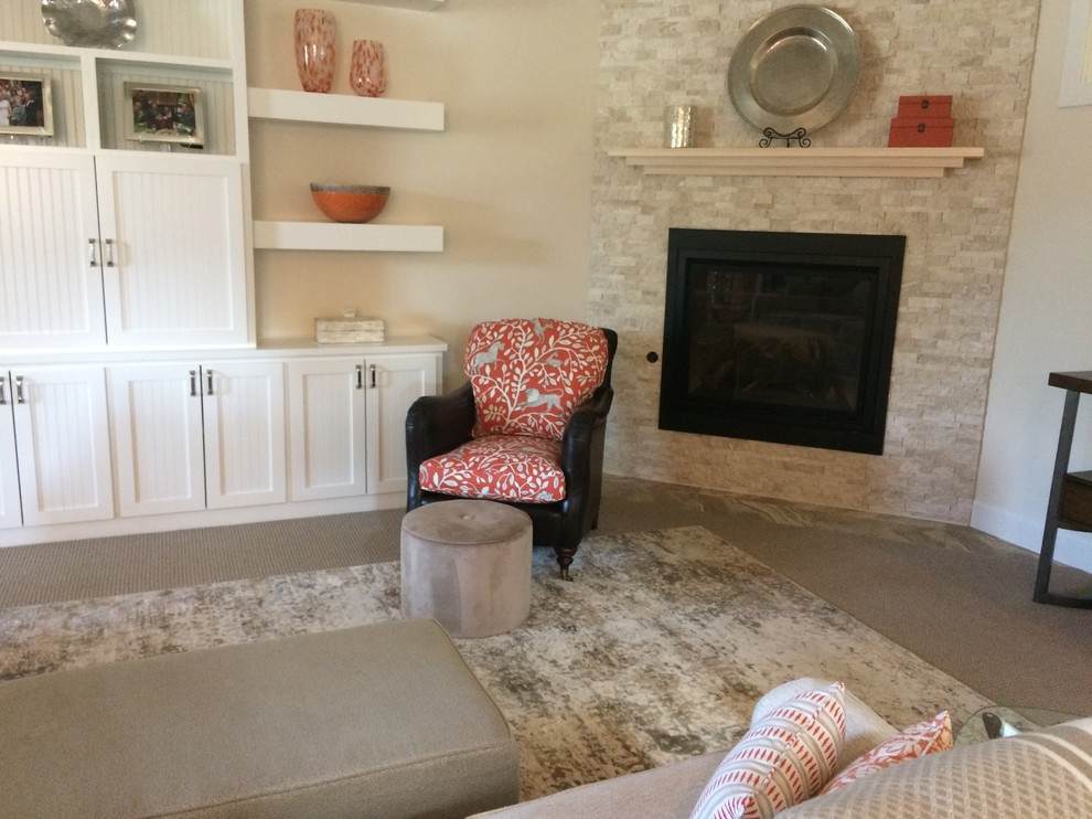 Esempio di un soggiorno classico di medie dimensioni e aperto con pareti beige, moquette, camino ad angolo, TV a parete e pavimento beige
