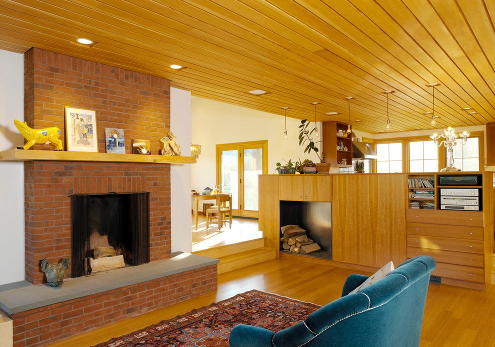 Diseño de salón contemporáneo con suelo de madera en tonos medios, todas las chimeneas y marco de chimenea de ladrillo