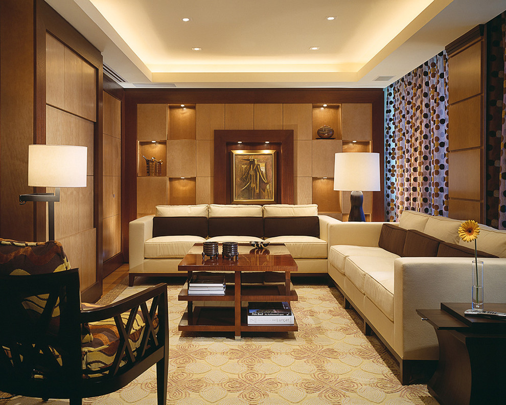 This is an example of a large world-inspired formal enclosed living room in Miami with beige walls, light hardwood flooring, no fireplace and a concealed tv.