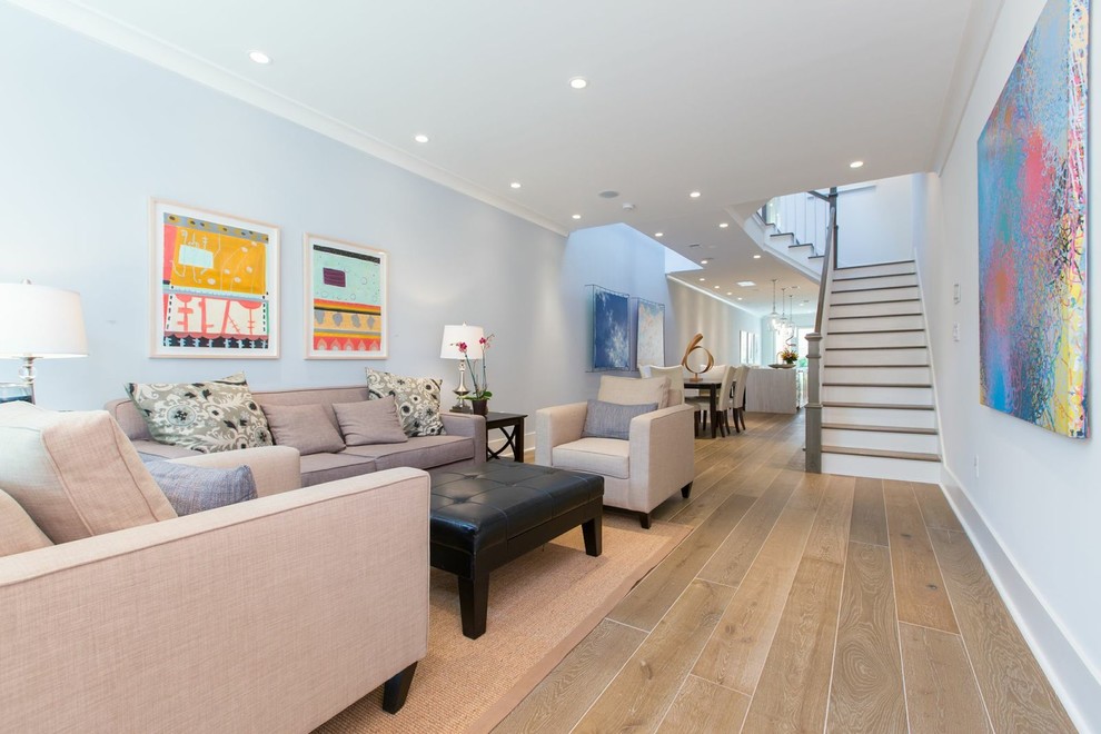 Cette image montre un salon design ouvert avec un mur bleu, un sol en bois brun et un escalier.