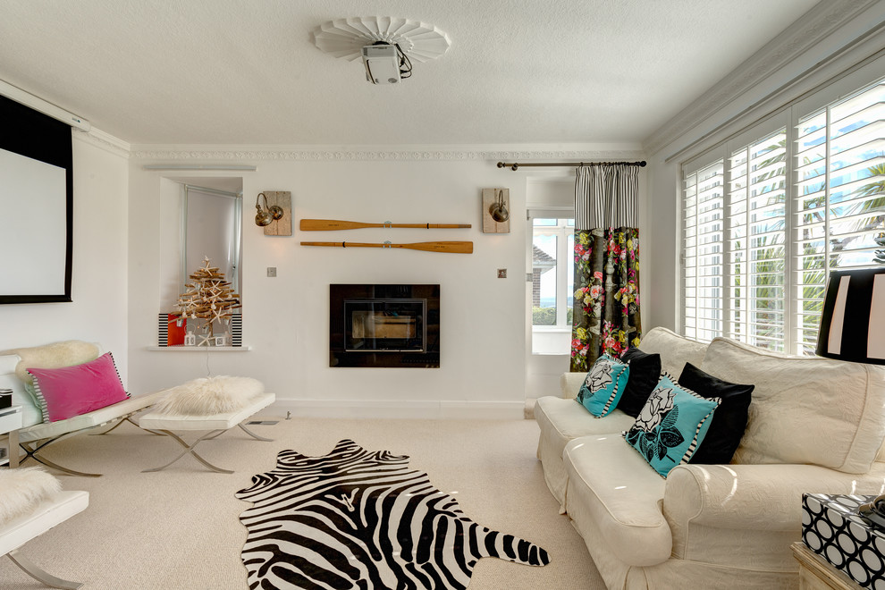 Aménagement d'un grand salon bord de mer ouvert avec un mur blanc, moquette et un téléviseur encastré.