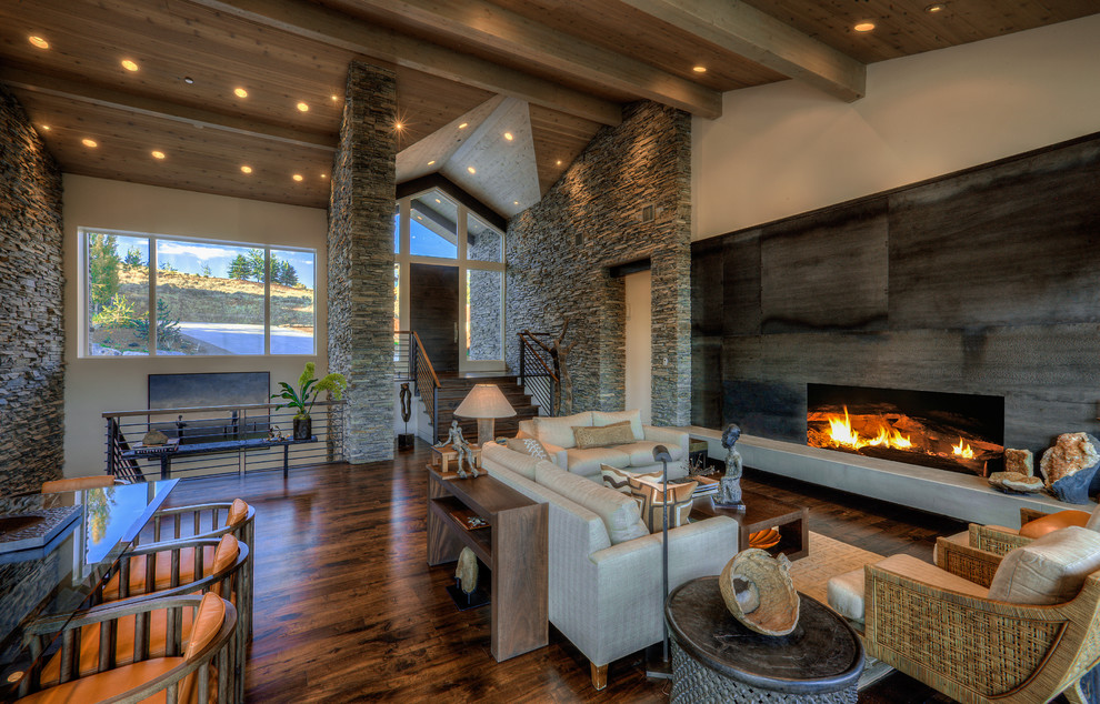 Example of a mid-sized mountain style loft-style dark wood floor living room design in Salt Lake City with beige walls, a standard fireplace and a concrete fireplace