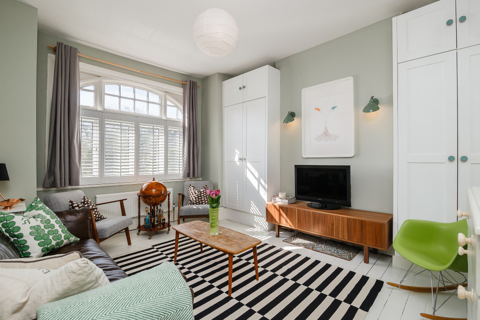 Klassisches Wohnzimmer mit grauer Wandfarbe, gebeiztem Holzboden und freistehendem TV in London