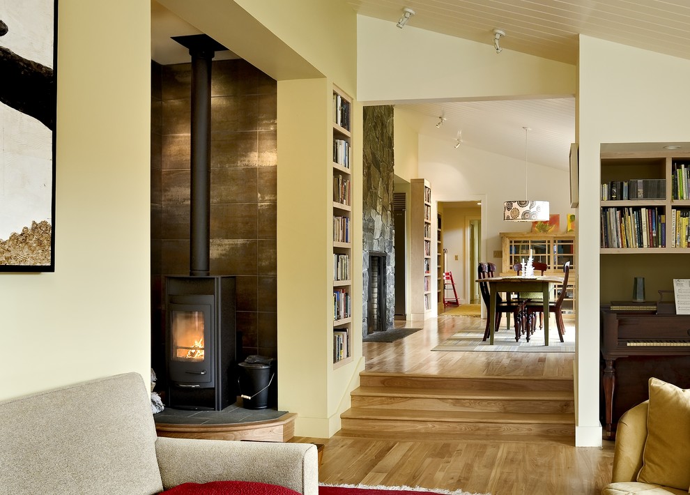 Living room library - contemporary living room library idea in Burlington with beige walls and a wood stove