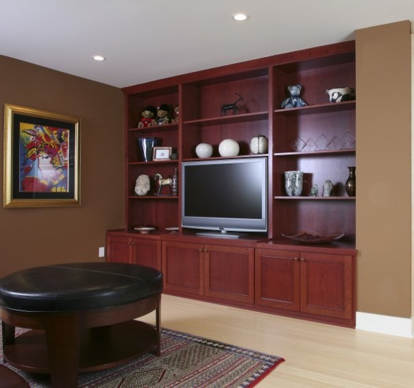 Imagen de salón tradicional con paredes marrones, suelo de bambú y pared multimedia
