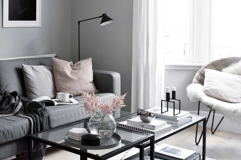 Bild på ett mellanstort minimalistiskt separat vardagsrum, med grå väggar, ljust trägolv, en standard öppen spis, en spiselkrans i trä, en fristående TV och beiget golv