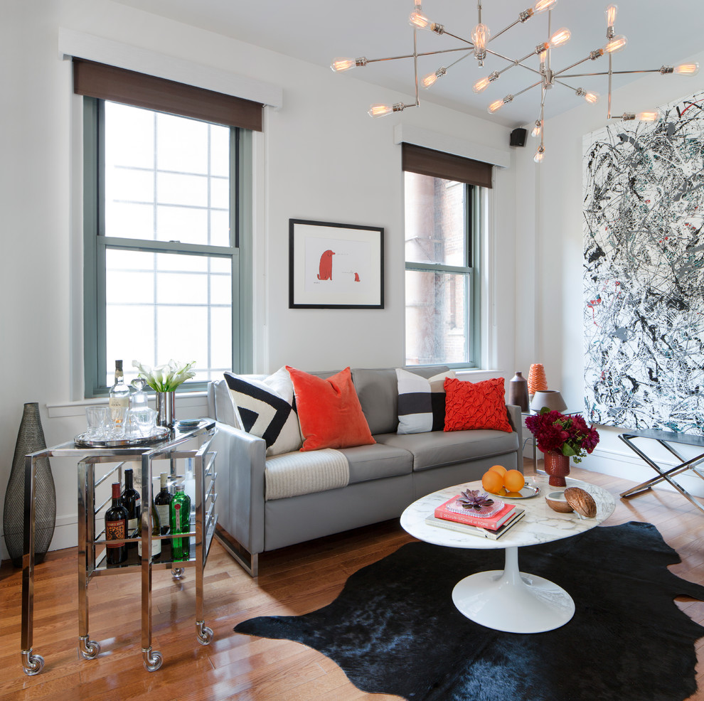 Esempio di un piccolo soggiorno minimalista con pareti bianche, pavimento in legno massello medio, parete attrezzata e pavimento marrone