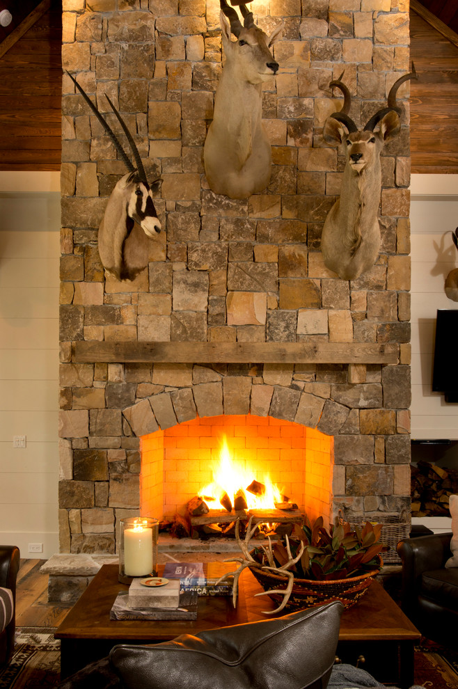 アトランタにあるラスティックスタイルのおしゃれなリビング (濃色無垢フローリング、標準型暖炉、石材の暖炉まわり、テレビなし) の写真