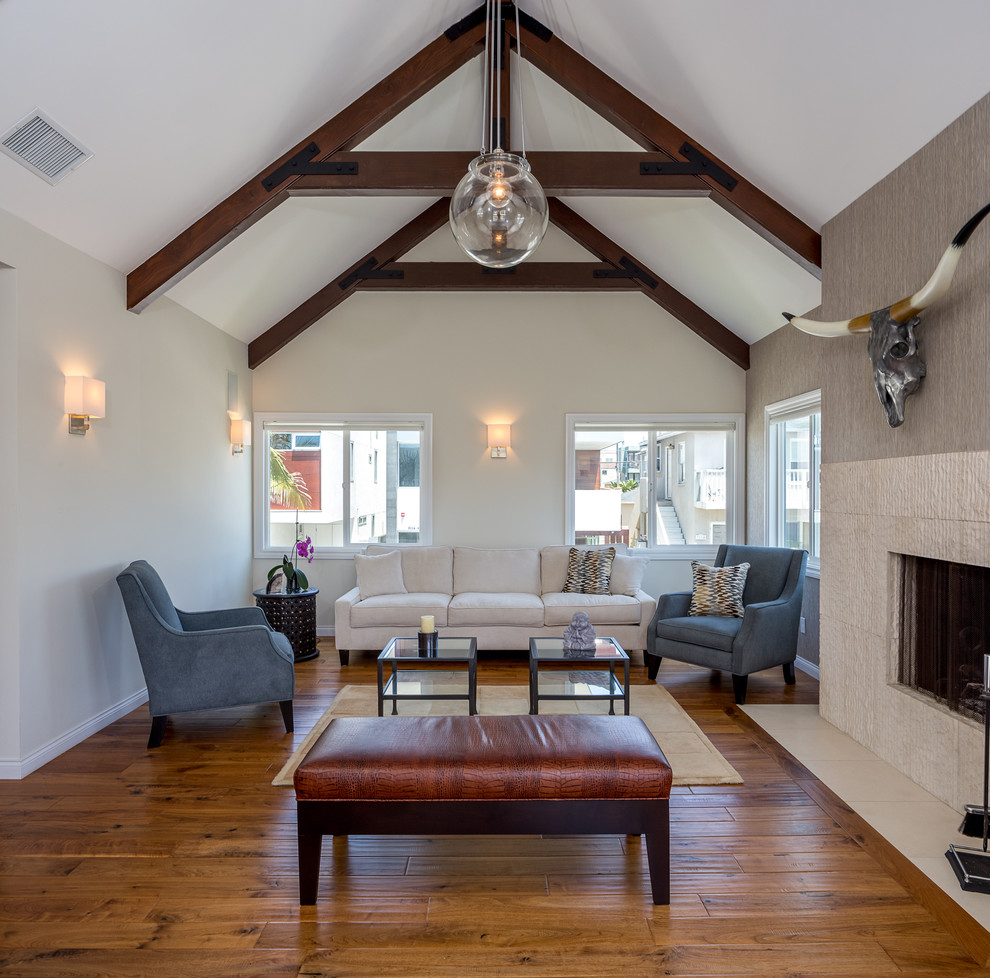 Inspiration for a mid-sized transitional open concept medium tone wood floor living room remodel in Los Angeles with white walls, a standard fireplace, a tile fireplace and no tv