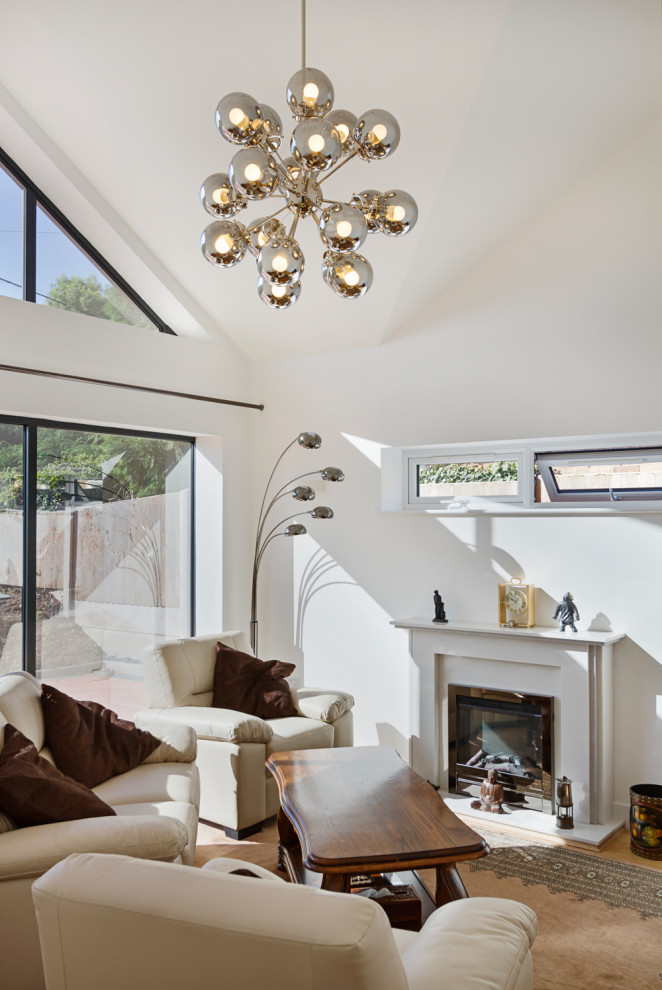 Living room - mid-sized modern formal and enclosed laminate floor, brown floor and vaulted ceiling living room idea in West Midlands with white walls, a standard fireplace, a stone fireplace and a corner tv