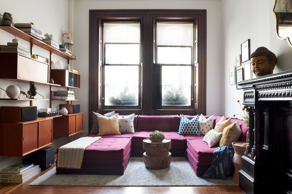 Foto di un soggiorno boho chic con pareti bianche, pavimento in legno massello medio, camino classico e pavimento marrone