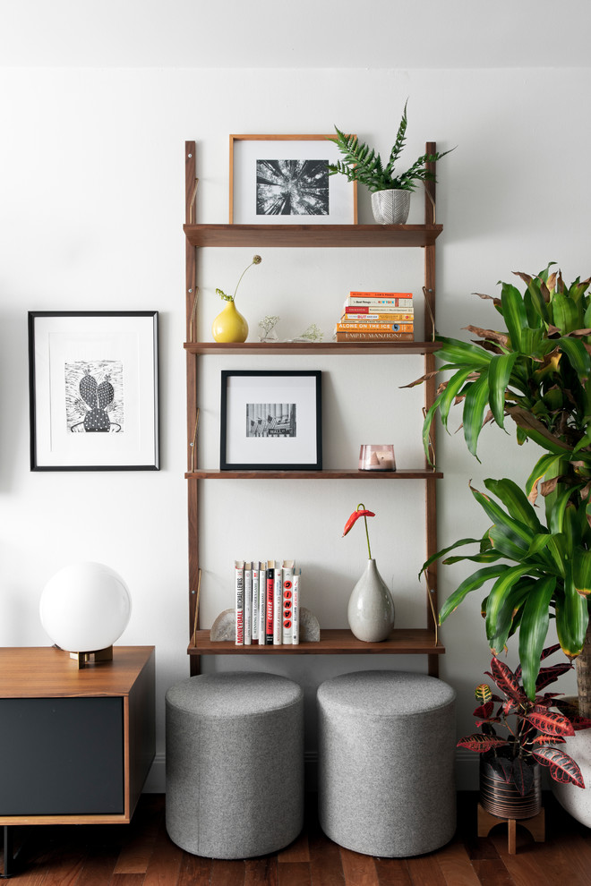 Diseño de salón abierto retro de tamaño medio sin chimenea con paredes grises, suelo de madera clara, televisor colgado en la pared y suelo marrón