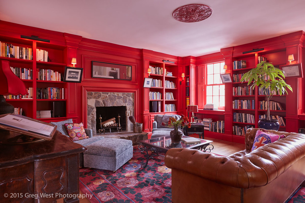 Großes, Repräsentatives, Fernseherloses, Offenes Stilmix Wohnzimmer mit roter Wandfarbe, braunem Holzboden, Kamin, Kaminumrandung aus Stein und braunem Boden in Boston