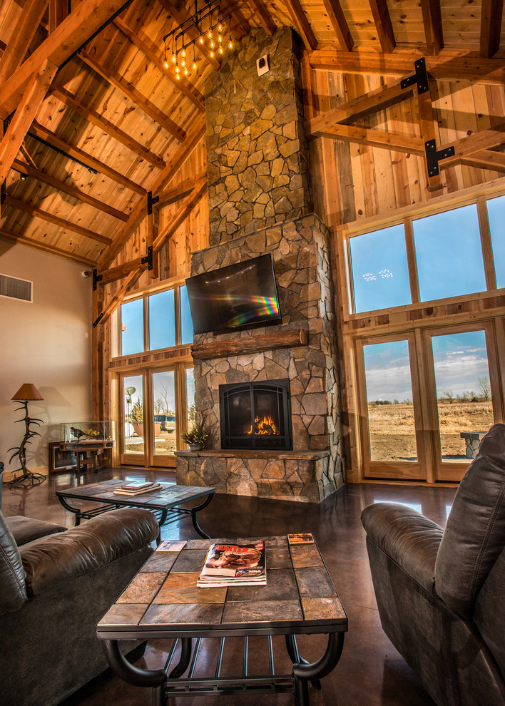Mountain style loft-style living room photo in Other with a stone fireplace, a wall-mounted tv and a standard fireplace