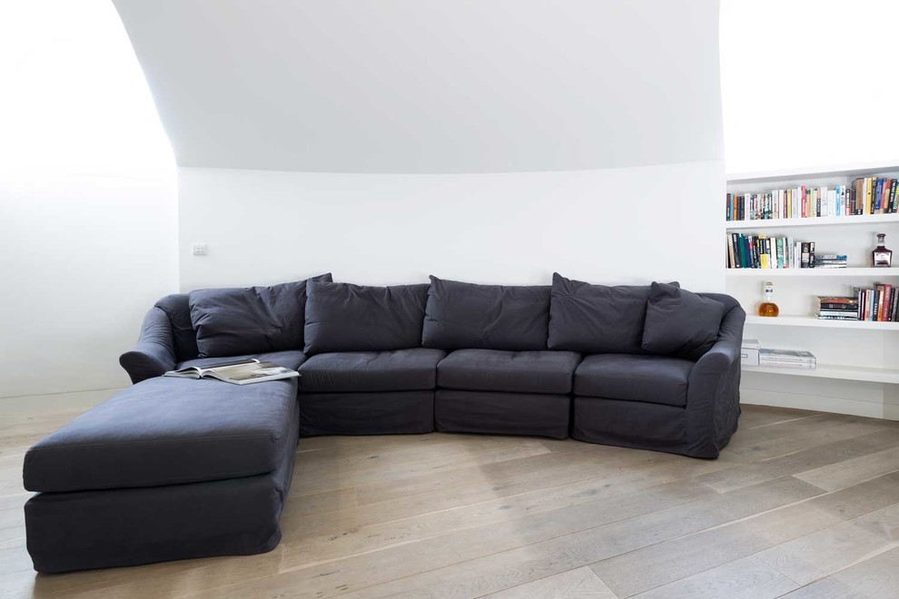Ispirazione per un soggiorno design di medie dimensioni e aperto con sala formale, pareti bianche, parquet chiaro e TV a parete