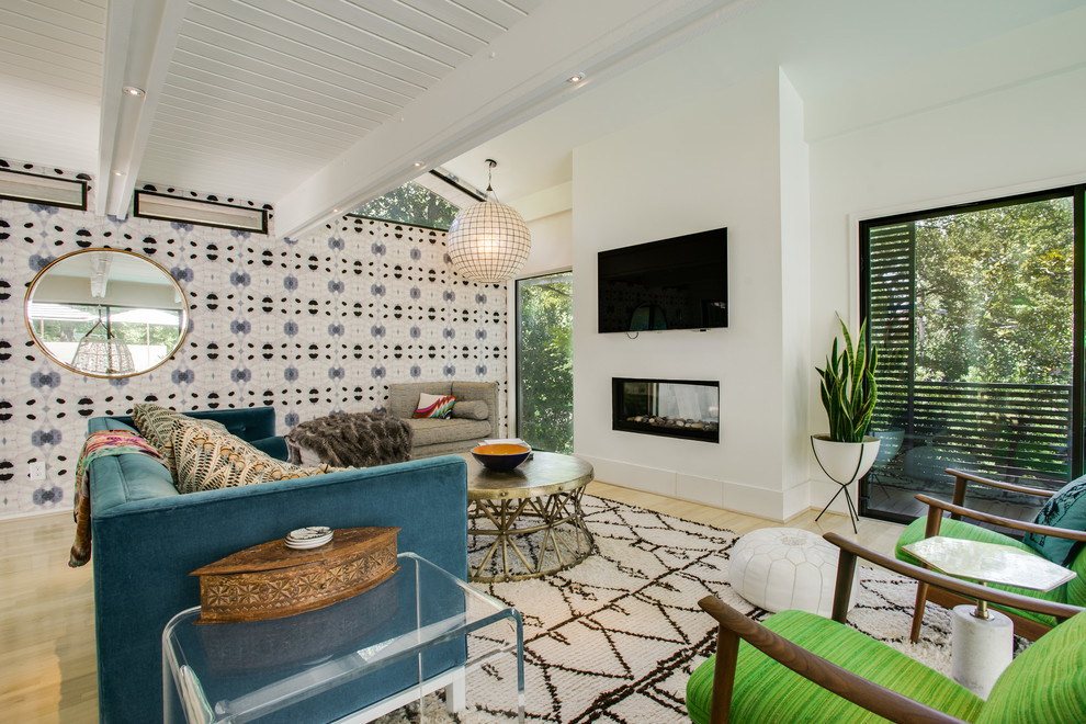Пример оригинального дизайна: большая открытая гостиная комната в стиле фьюжн с белыми стенами, светлым паркетным полом и телевизором на стене