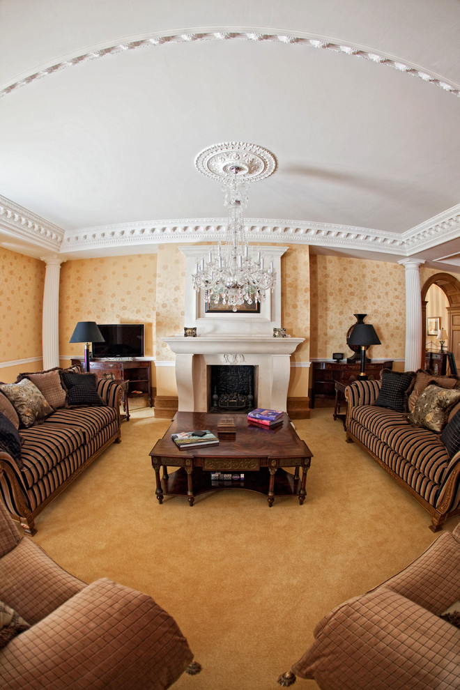 Design ideas for a large traditional living room in Surrey with yellow walls, carpet, a standard fireplace, a stone fireplace surround, a freestanding tv and yellow floors.