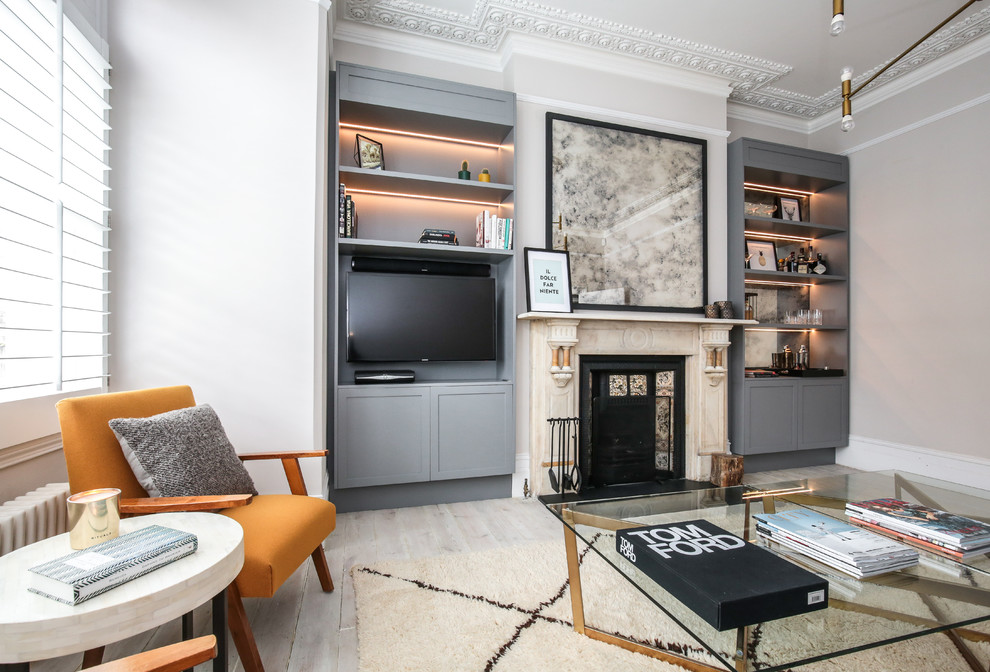 This is an example of a contemporary living room in London with beige walls, painted wood flooring, a standard fireplace, a wall mounted tv and white floors.