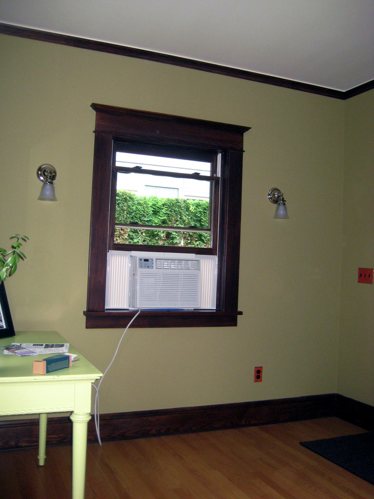 Cette photo montre un petit salon craftsman fermé avec un mur vert, parquet clair, aucune cheminée et aucun téléviseur.
