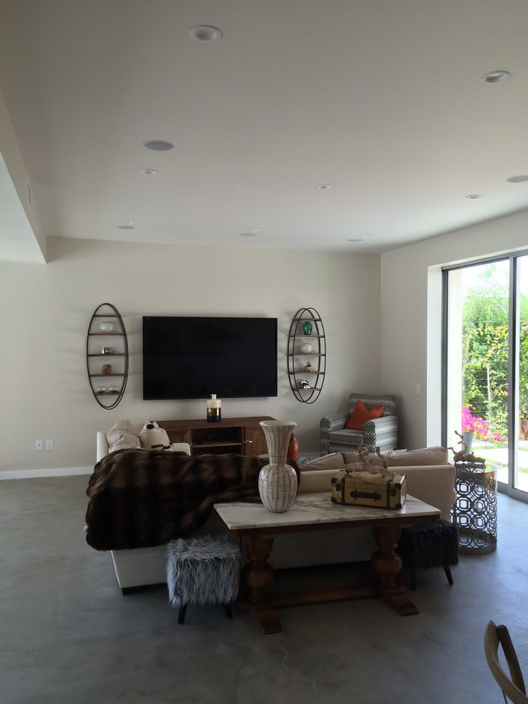 Imagen de salón abierto contemporáneo de tamaño medio con paredes blancas, suelo de madera en tonos medios y televisor colgado en la pared