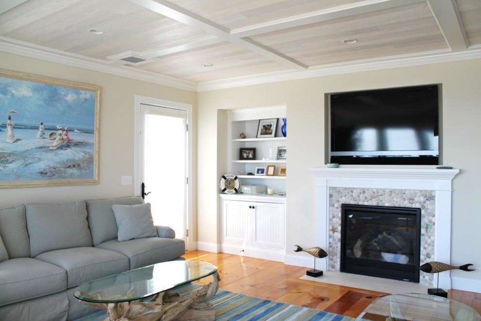 Offenes Maritimes Wohnzimmer mit beiger Wandfarbe, braunem Holzboden, Kamin und Kaminumrandung aus Stein in Boston