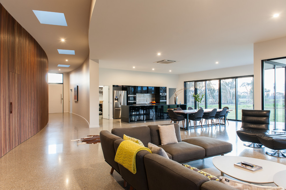 Großes, Offenes Modernes Wohnzimmer mit weißer Wandfarbe, Betonboden und Multimediawand in Melbourne