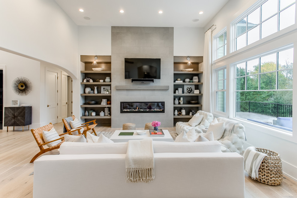 Inspiration for a large contemporary open plan living room in Grand Rapids with white walls, light hardwood flooring, a ribbon fireplace, a tiled fireplace surround, a wall mounted tv and beige floors.
