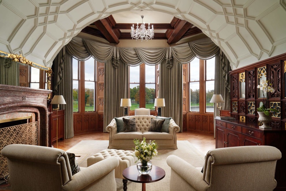 Diseño de salón para visitas clásico con suelo de madera en tonos medios, todas las chimeneas y cortinas