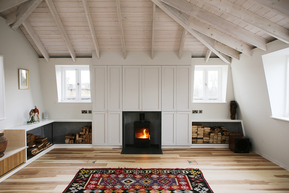 Design ideas for a medium sized scandinavian formal enclosed living room in London with white walls, medium hardwood flooring, a wood burning stove, a stone fireplace surround and a concealed tv.