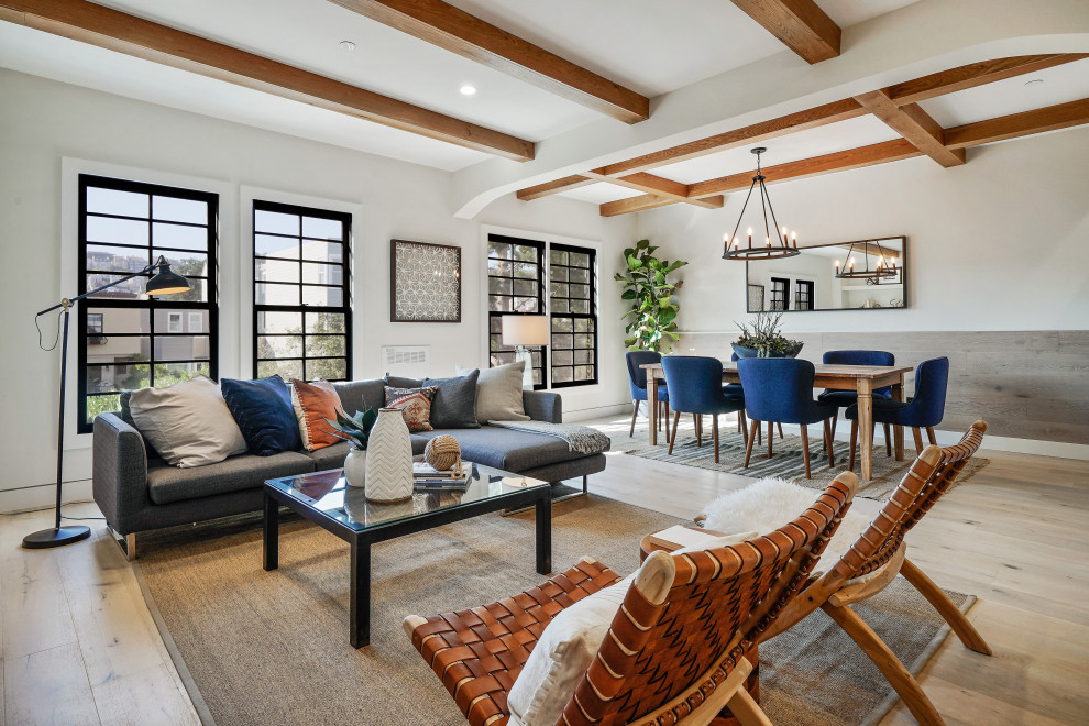 Contemporary open plan living room in San Francisco with white walls, light hardwood flooring, beige floors and exposed beams.
