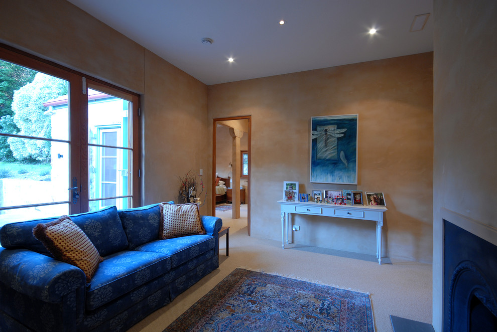 Стильный дизайн: изолированная гостиная комната среднего размера в средиземноморском стиле с с книжными шкафами и полками, бежевыми стенами, паркетным полом среднего тона и стандартным камином - последний тренд