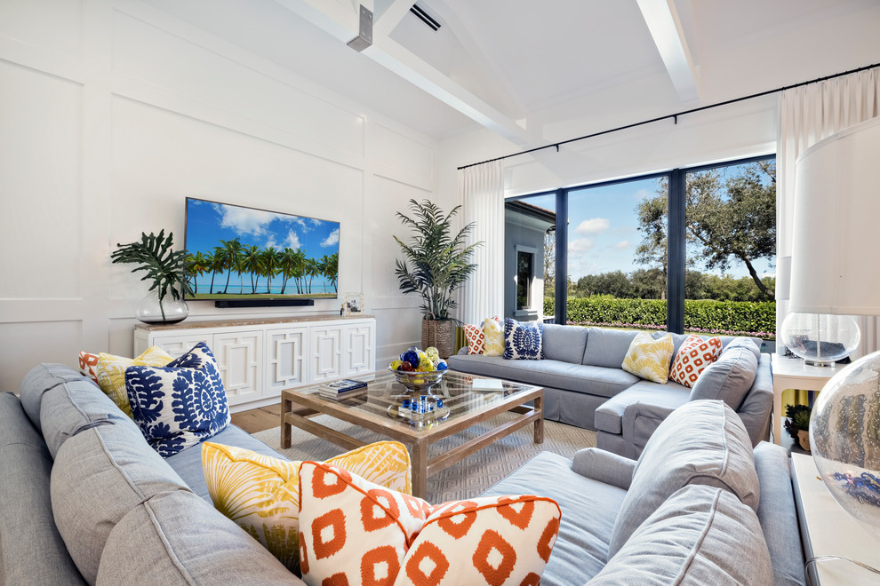This is an example of a nautical living room in Miami with white walls, medium hardwood flooring and brown floors.