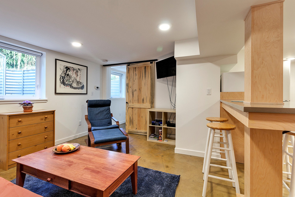 Small minimalist open concept concrete floor and beige floor living room photo in Portland with beige walls, no fireplace and a wall-mounted tv
