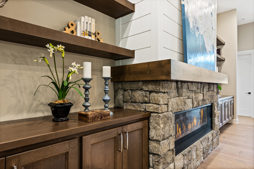 ポートランドにあるラグジュアリーな広いトラディショナルスタイルのおしゃれなLDK (ベージュの壁、竹フローリング、標準型暖炉、石材の暖炉まわり、マルチカラーの床) の写真