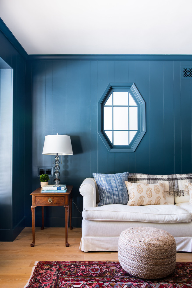 Bild på ett mellanstort vintage allrum med öppen planlösning, med ett finrum, blå väggar, mellanmörkt trägolv, en standard öppen spis, en spiselkrans i tegelsten, en väggmonterad TV och brunt golv