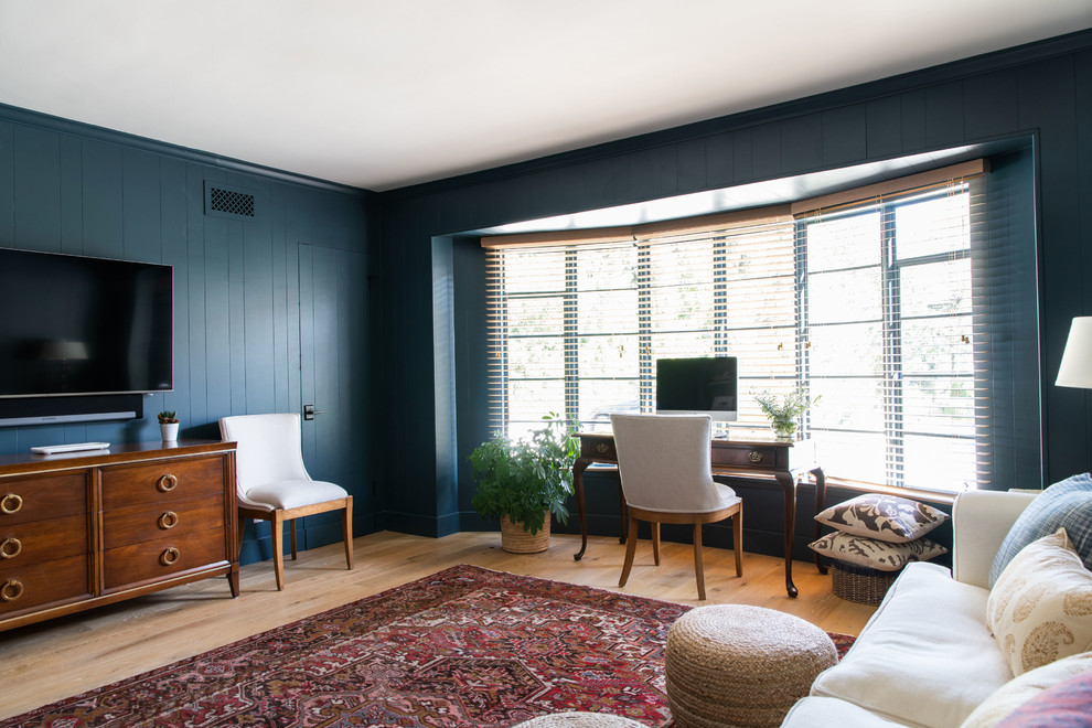 Cette photo montre un salon chic de taille moyenne et ouvert avec une salle de réception, un sol en bois brun, une cheminée standard, un manteau de cheminée en brique, un téléviseur fixé au mur, un sol marron et un mur bleu.