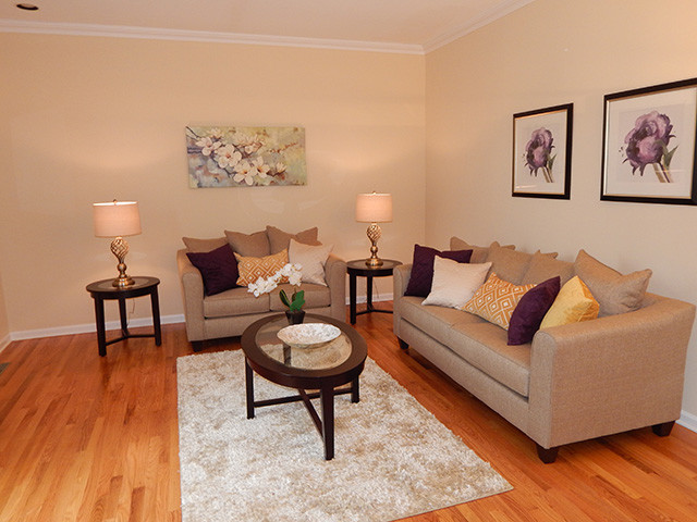 Idee per un soggiorno design aperto con pareti beige e pavimento in legno massello medio
