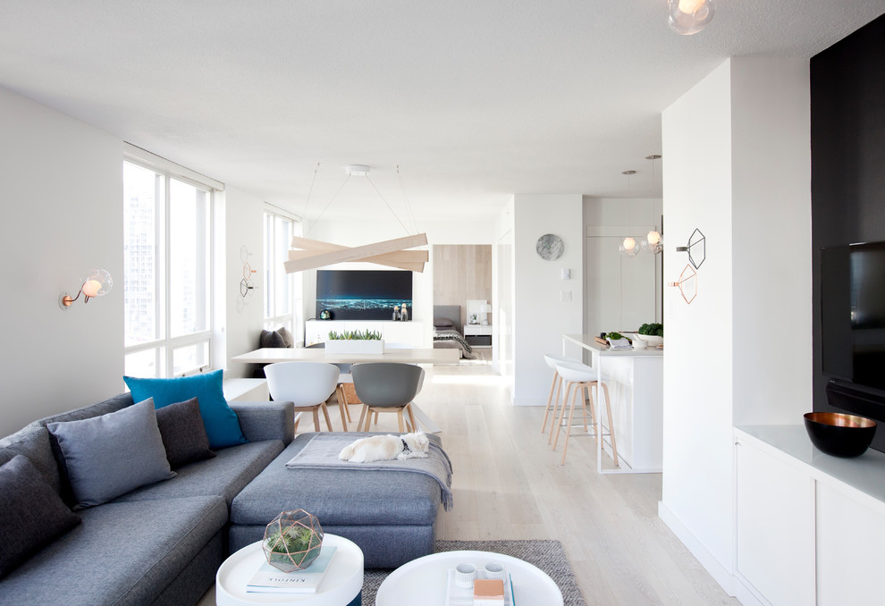 Kleines, Repräsentatives, Offenes Nordisches Wohnzimmer mit weißer Wandfarbe, hellem Holzboden und TV-Wand in Vancouver