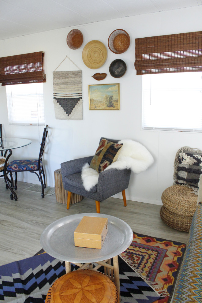 Immagine di un piccolo soggiorno bohémian chiuso con pareti bianche, pavimento in vinile, TV autoportante e pavimento grigio