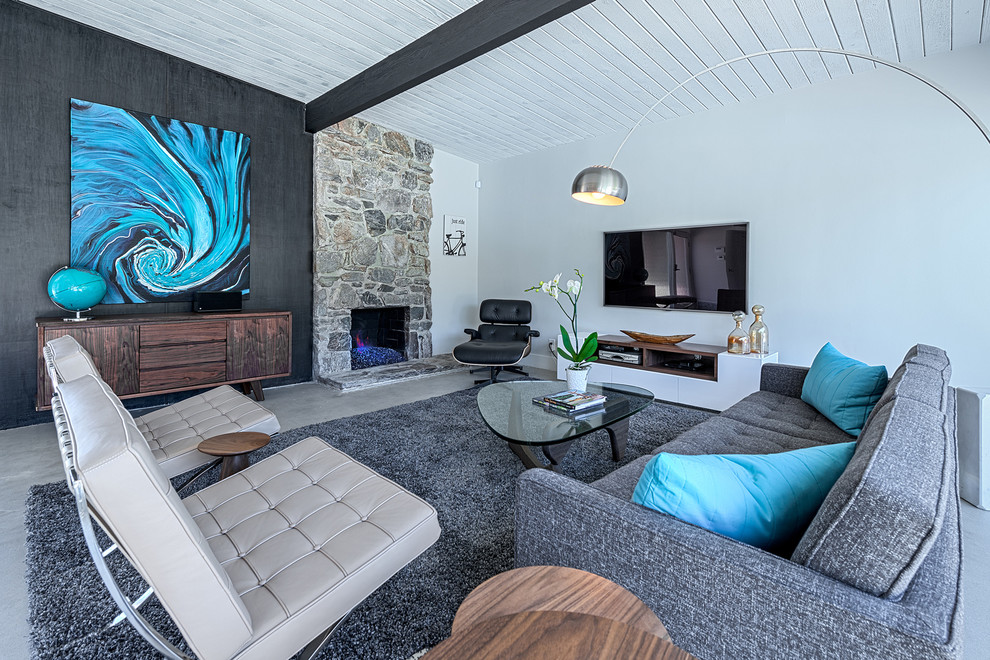 Пример оригинального дизайна: гостиная комната в стиле ретро с белыми стенами, стандартным камином и фасадом камина из камня